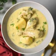 a plate of yogurt based chicken and potato curry