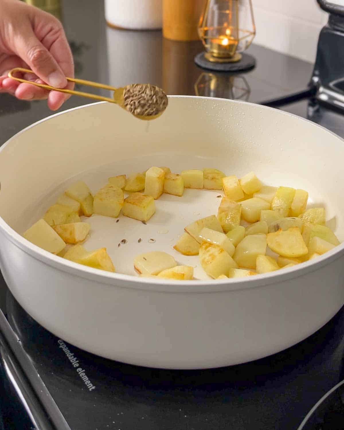 adding cumin to the pan