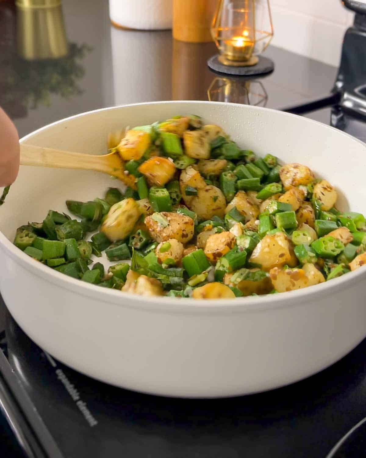 mixing bhind/okra and chilies with potatoes