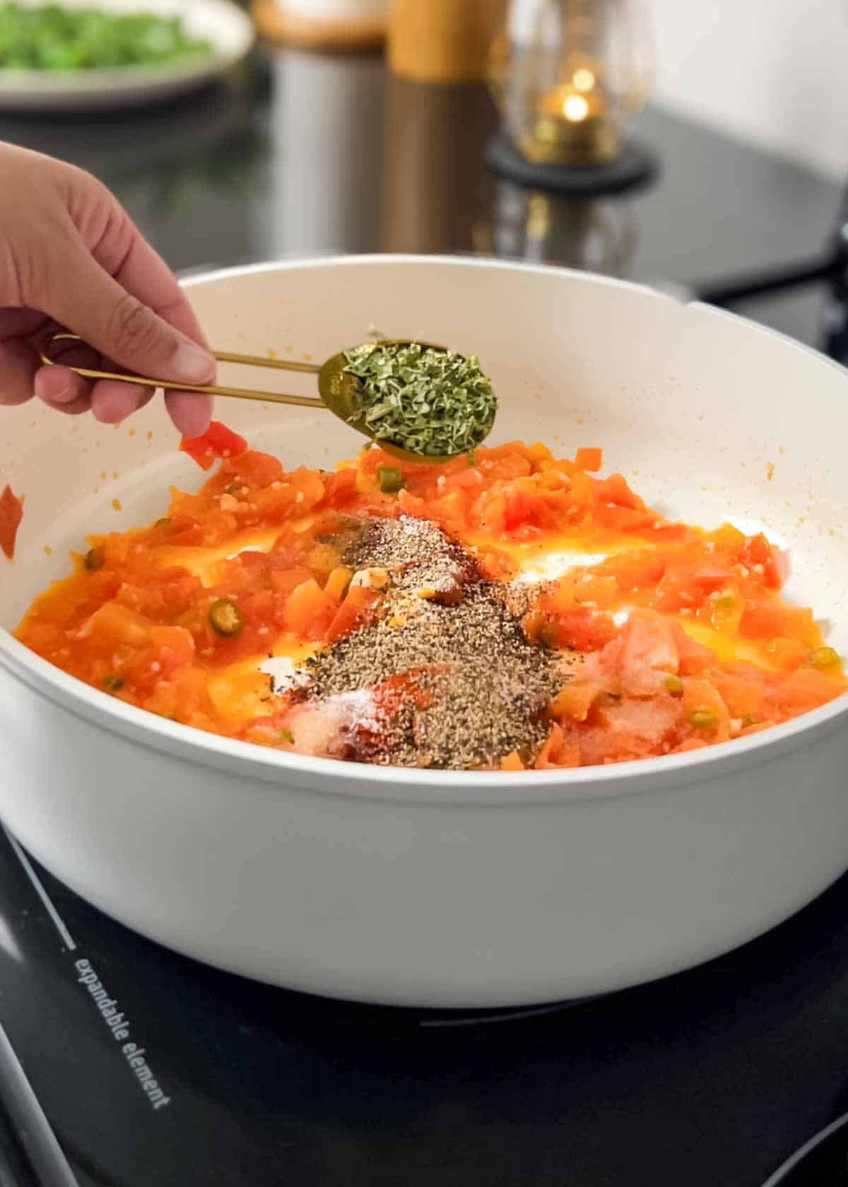 adding seasonings to the tomato base