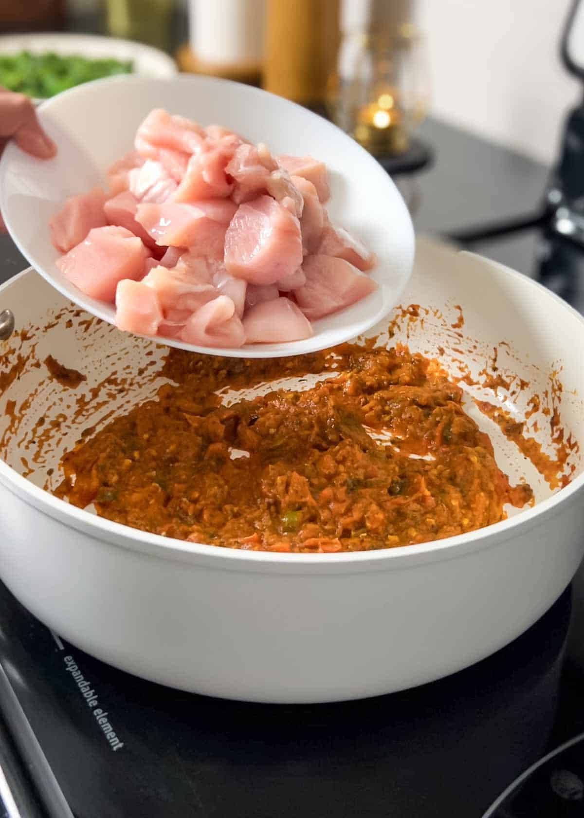 adding chicken pieces to the pan