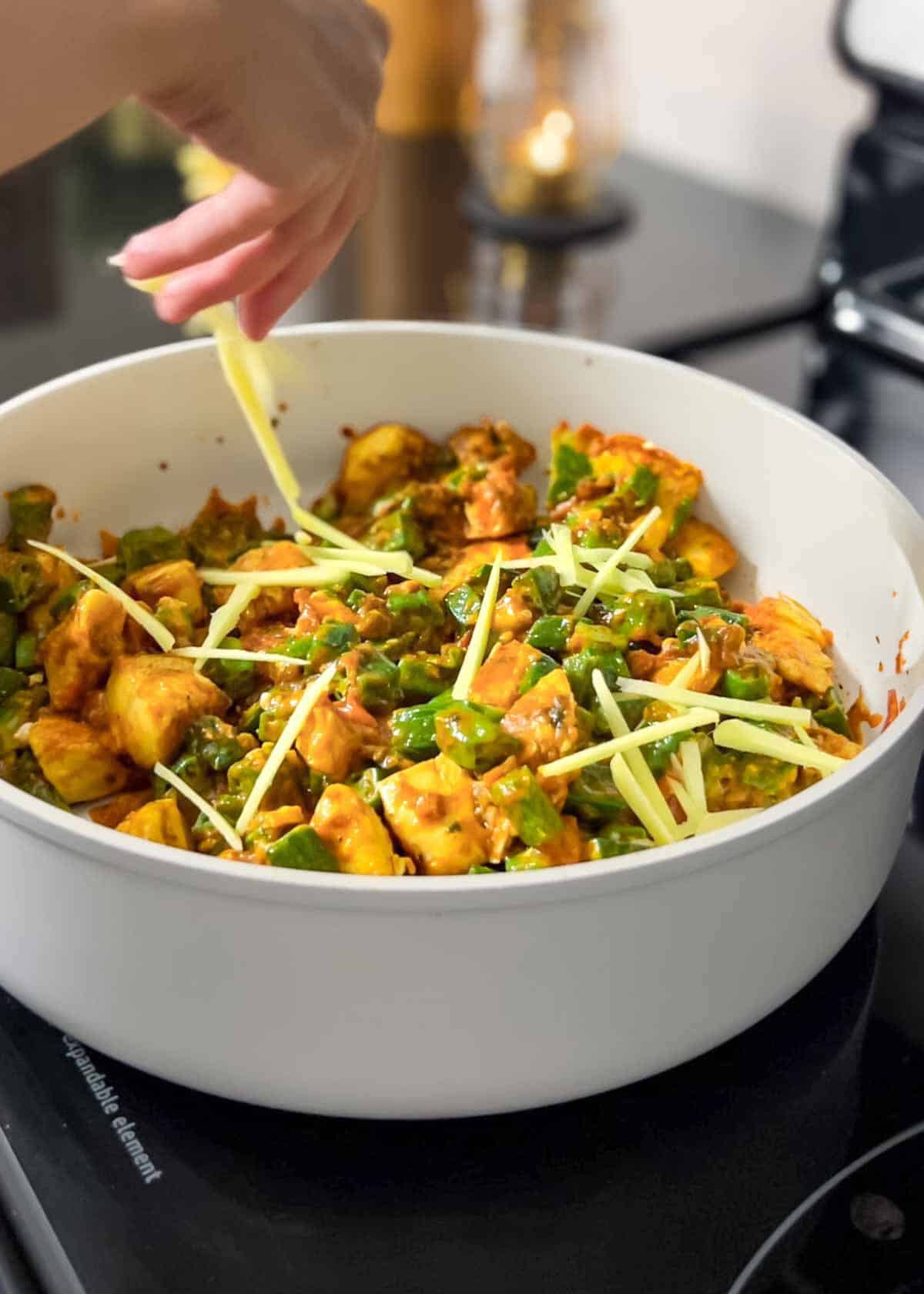 topping bhindi chicken with julienned ginger