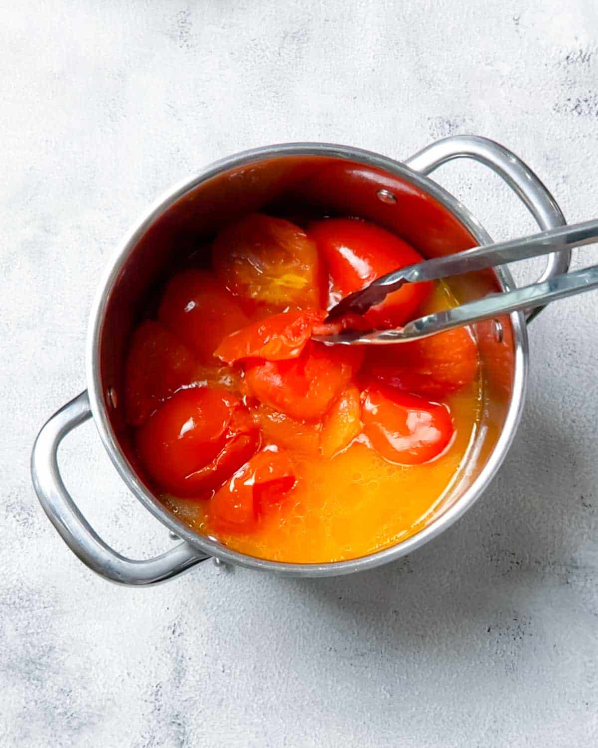 cooking halved tomatoes then removing the peel