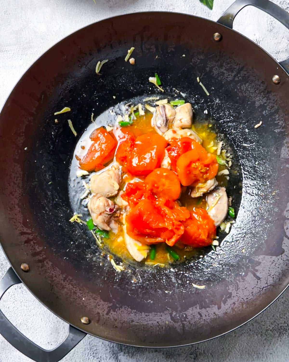 adding cooked tomatoes to the karahi