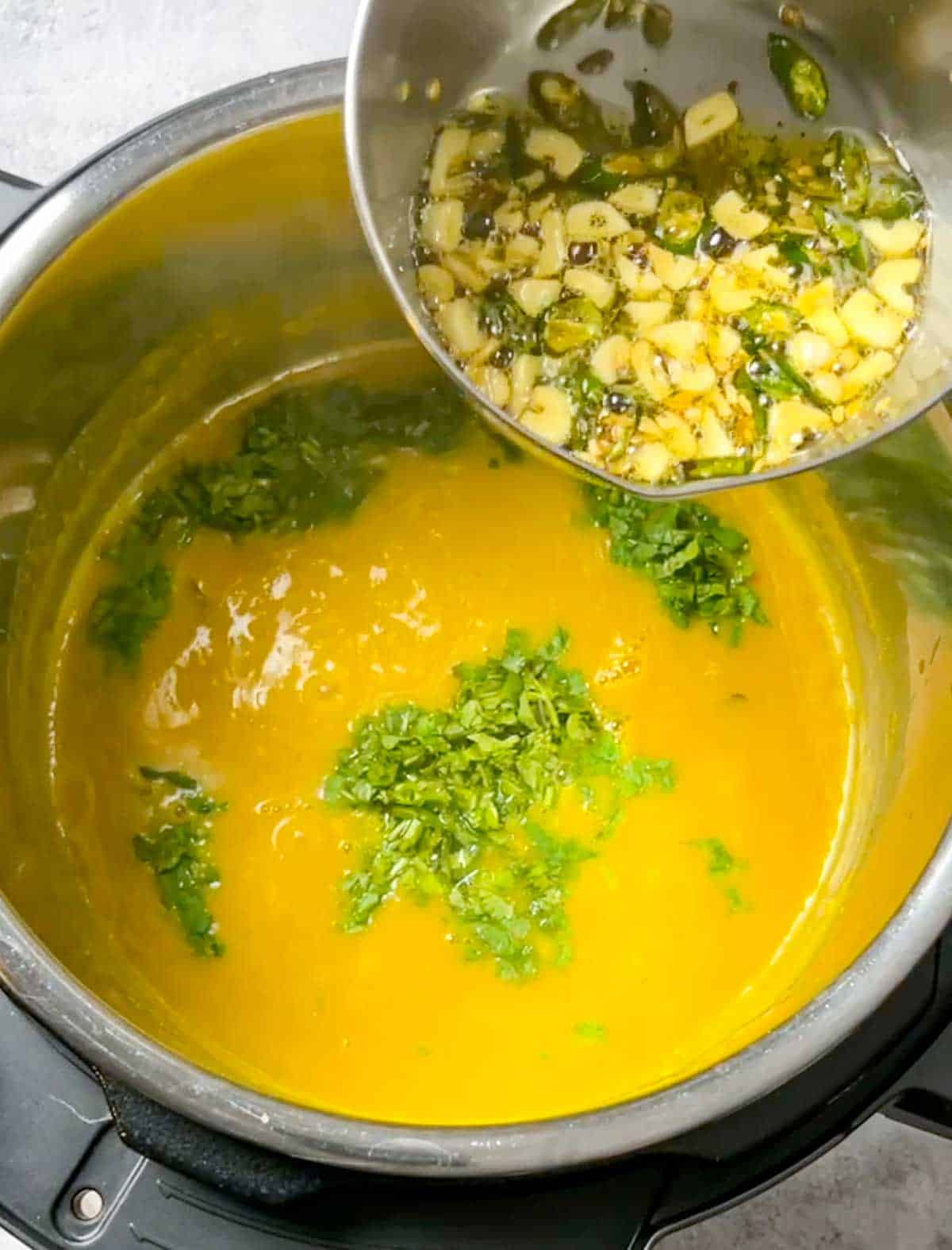 adding tarka, lemon juice and cilantro to dal