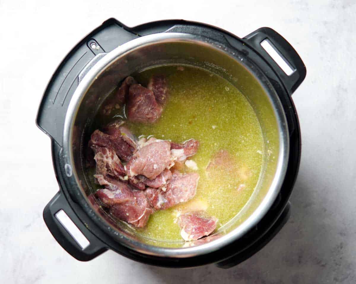 beef pieces and seasoned broth in an instant pot