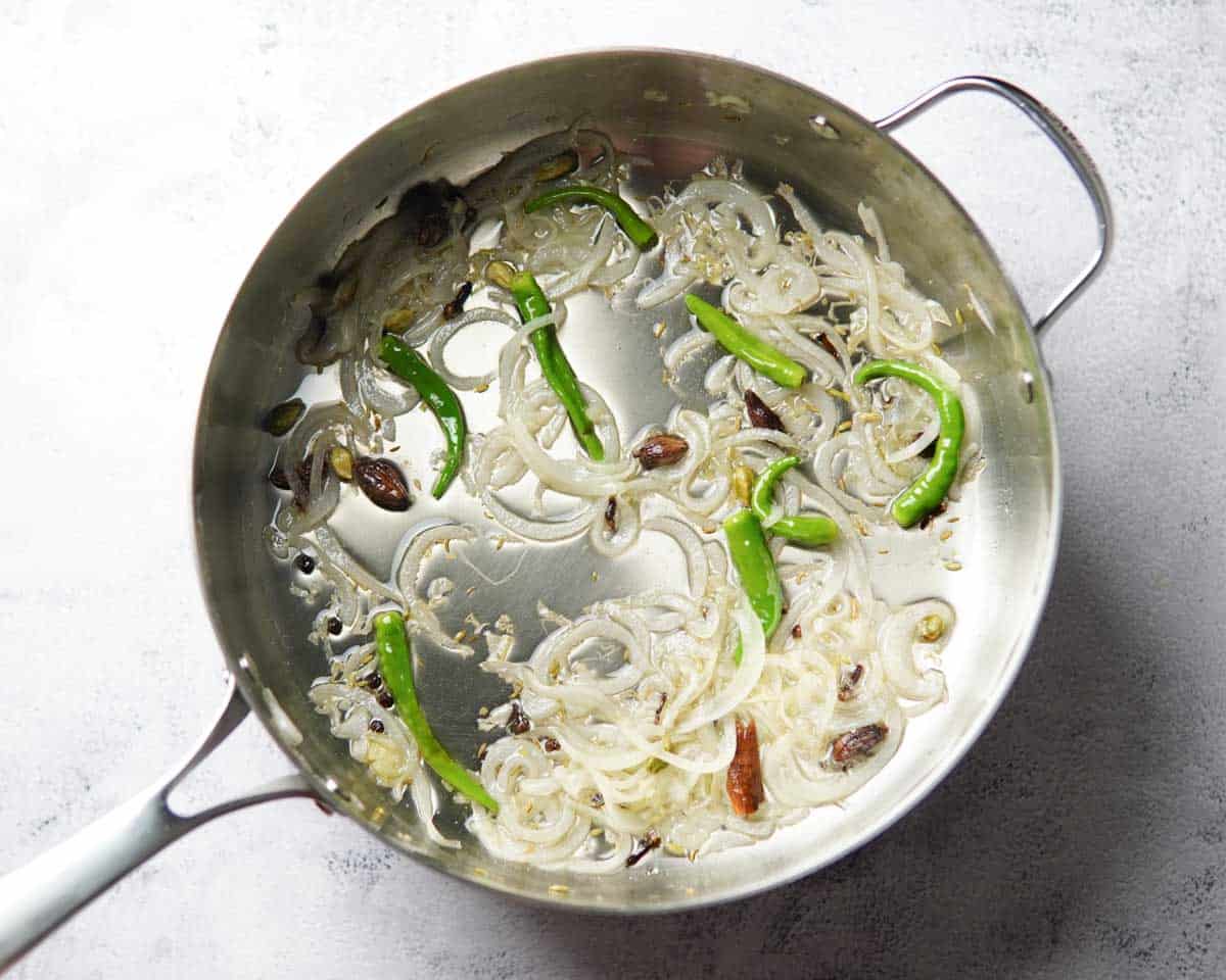 sautéed onion, chilies and whole spices in a pan