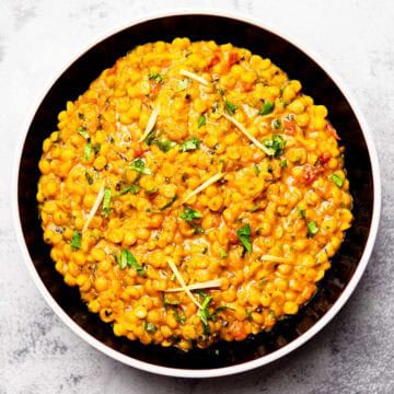 chana dal topped with julienned ginger, and cilantro served on a plate