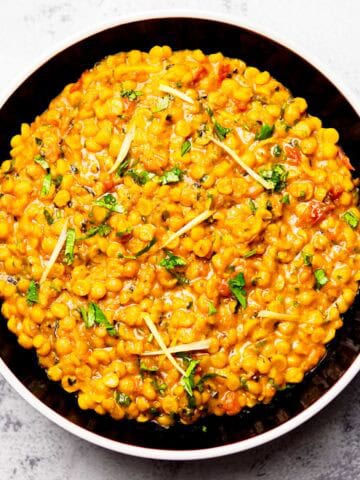 chana dal topped with julienned ginger, and cilantro served on a plate
