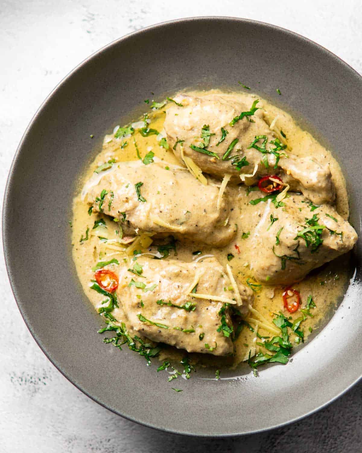 a plate containing chicken white karahi