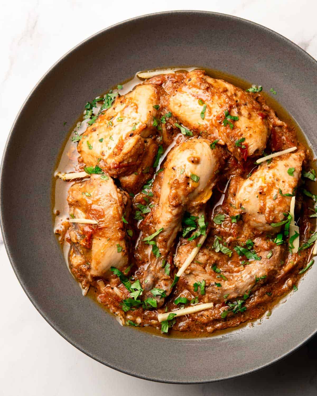 kali mirch chicken karahi on a plate topped with cilantro