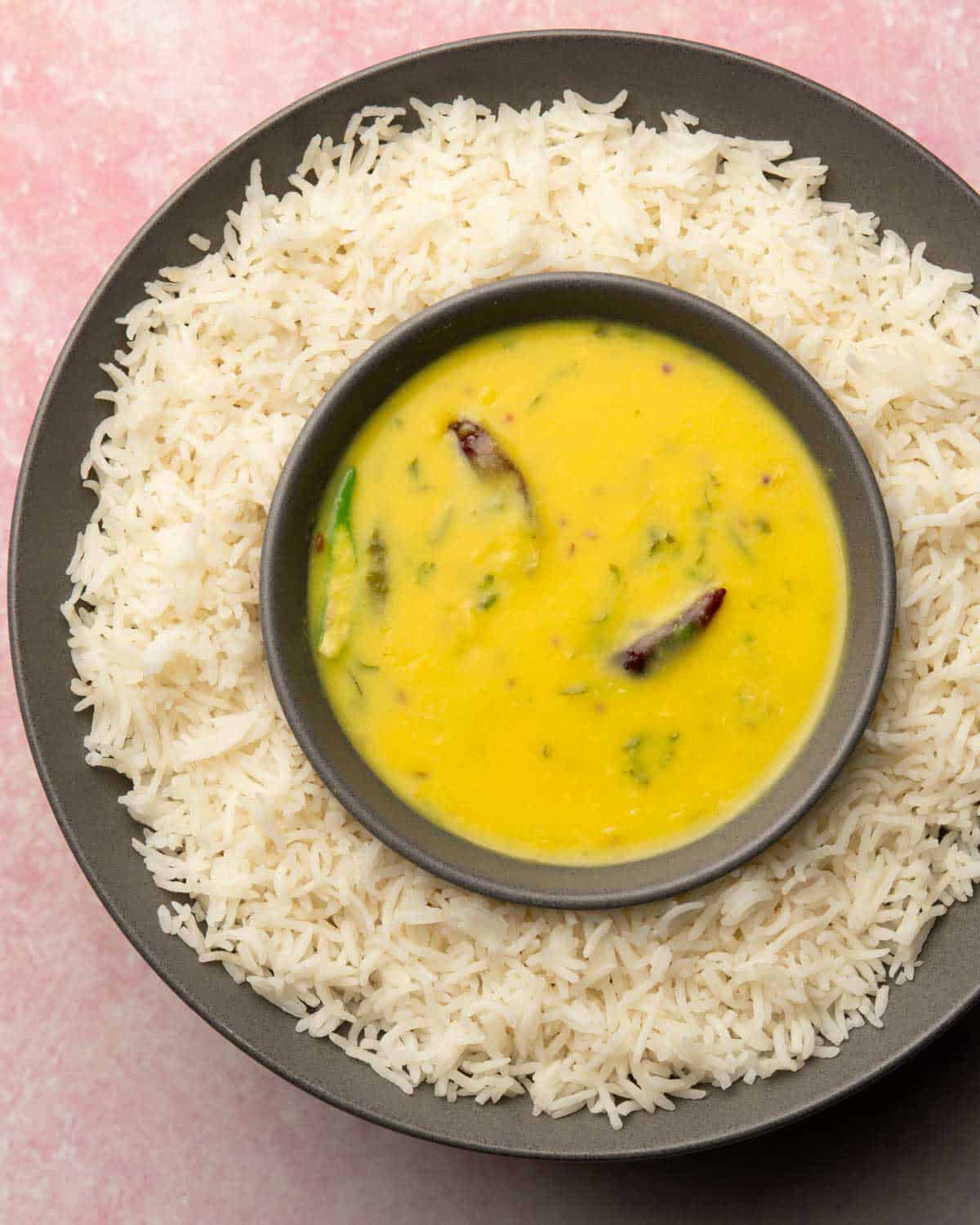 moong dal in a bowl that's on a plate containing rice