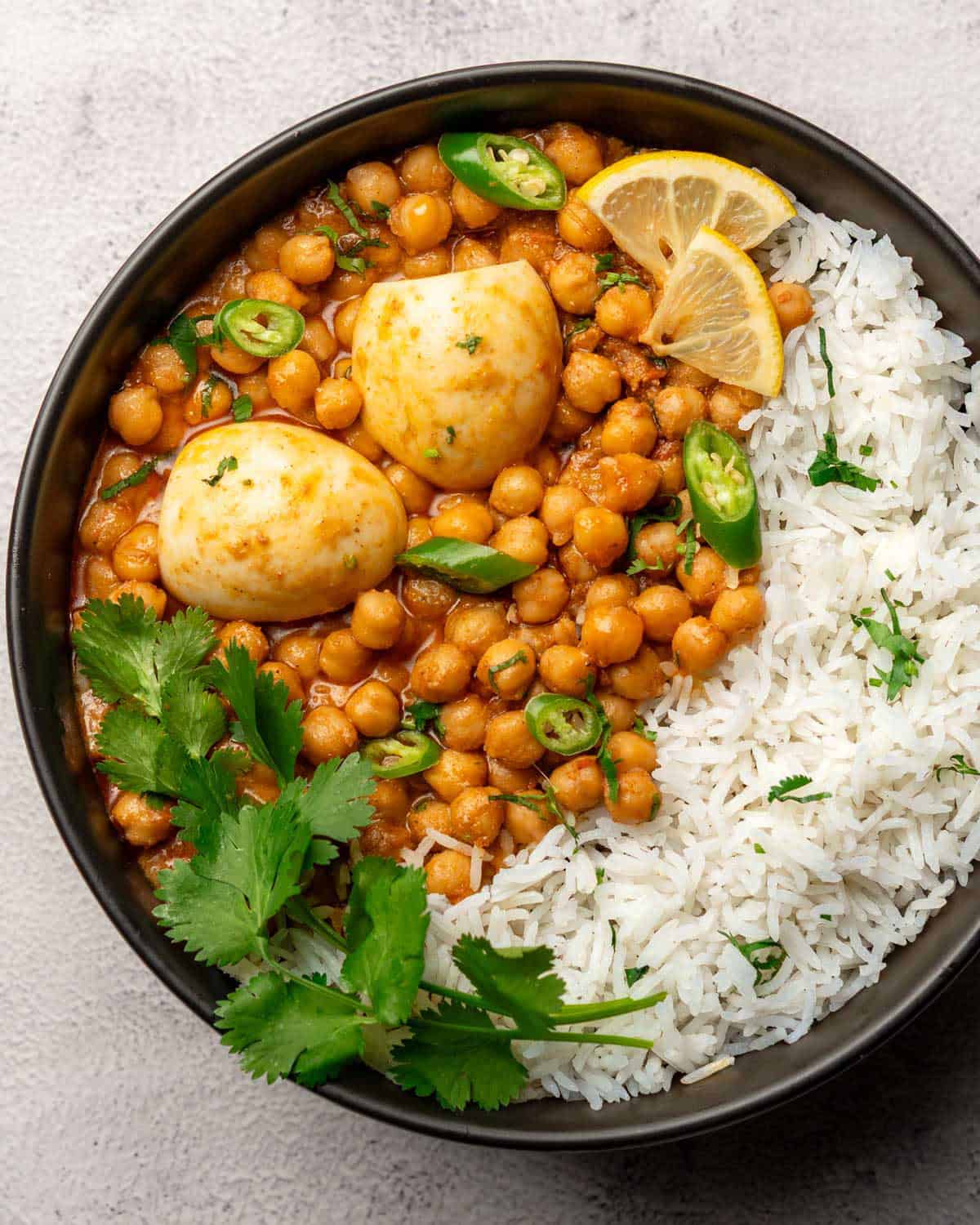 anda chana served on a plate alongside rice