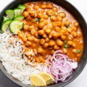 chickpea curry served with rice, onions, lemon and cucumber